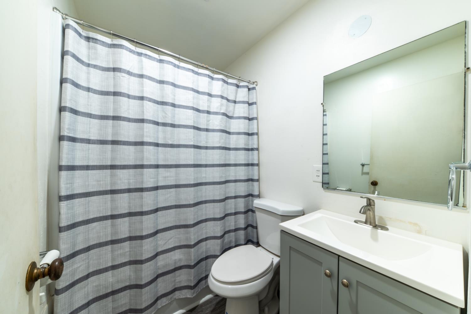 1004 West Pontiac Way Fresno, CA 93705 - Photo 23 of 34 a bathroom with a sink a toilet and shower curtain