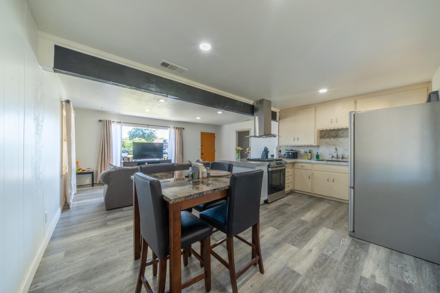 1004 West Pontiac Way Fresno, CA 93705 - Photo 7 of 34 a kitchen with a dining table chairs and refrigerator
