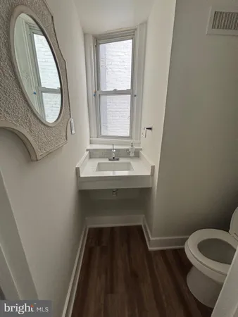 a bathroom with a toilet a sink and a mirror