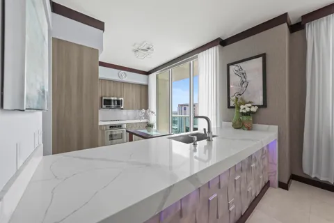 a large white kitchen with a large window and sink