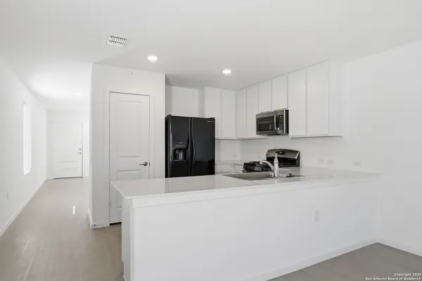 a kitchen with stainless steel appliances a refrigerator and a stove top oven