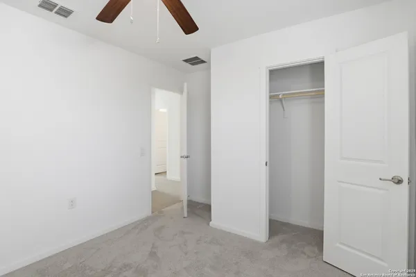 an empty room with a window and a fan