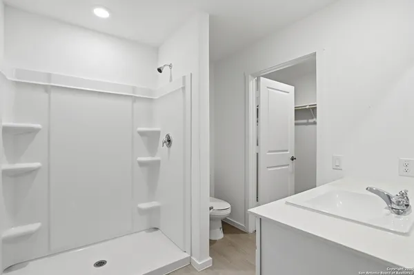 a bathroom with a sink a toilet and shower