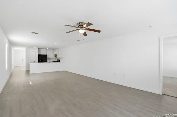 wooden floor in an empty room with a ceiling fan