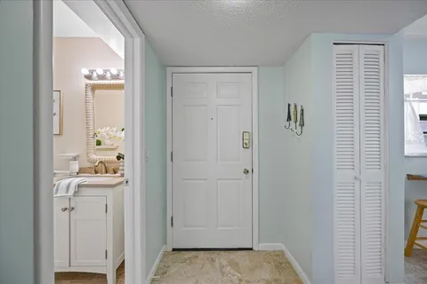 a view of a hallway with bathroom and a window