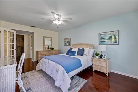 a bedroom with a large bed a chandelier and dresser