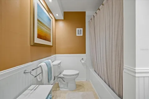 a bathroom with a toilet and a shower curtain