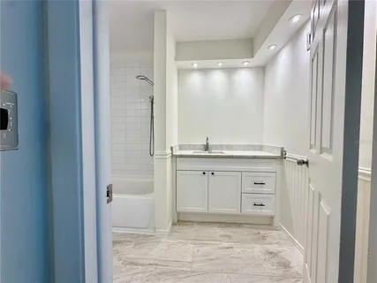a bathroom with a granite countertop sink mirror and shower
