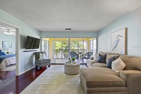 a living room with furniture a flat screen tv and a large window