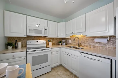 a kitchen with white cabinets and white appliances
