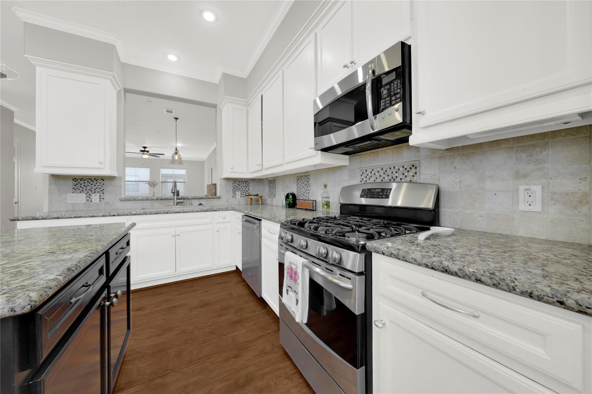 2609 Riverside Drive, Unit C Houston, TX 77004 - Photo 13 of 32 a kitchen with stainless steel appliances granite countertop a stove top oven a sink dishwasher and white cabinets with wooden floor