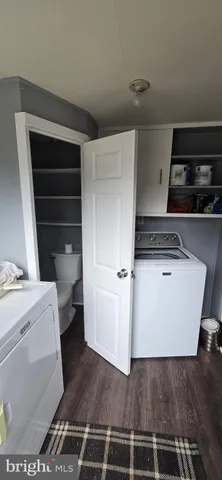 a walk in closet with wooden floor