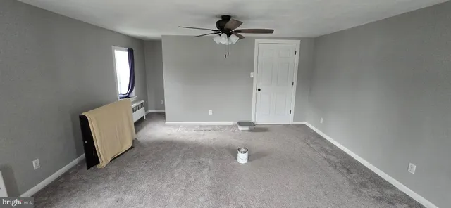 a kitchen with a refrigerator wooden floor and ceiling fan