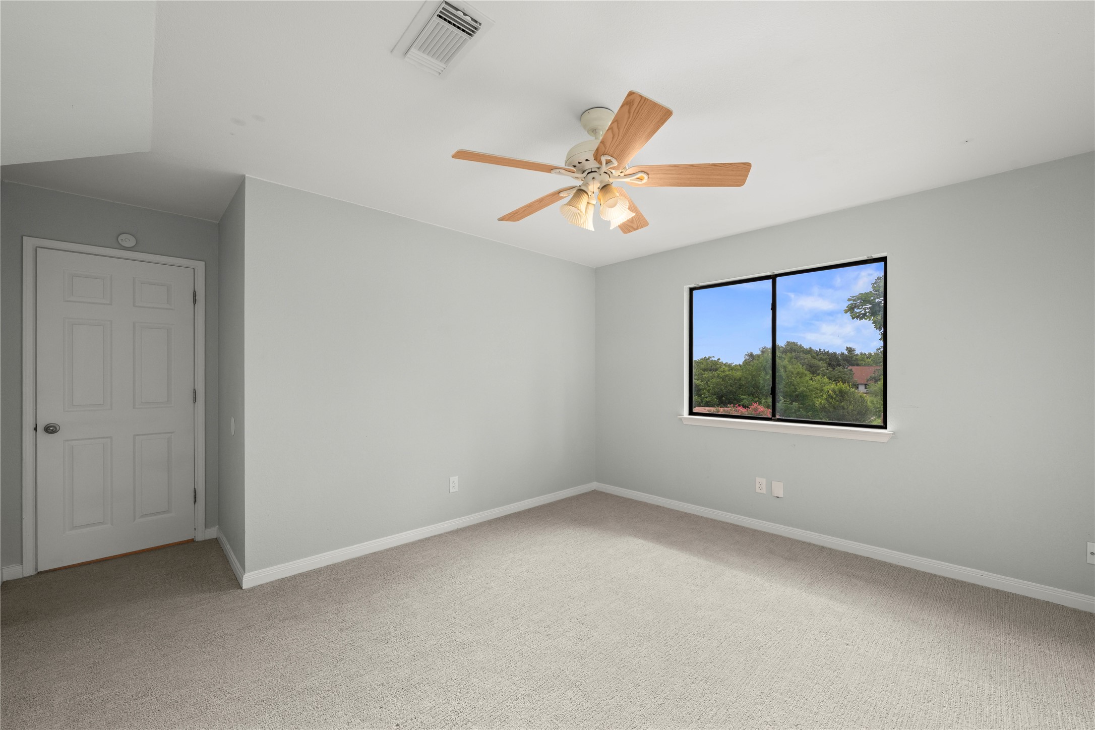 1329 Quail Ravine Round Rock, TX 78664 - Photo 10 of 39 Plush carpeting and a large window framing tree-lined views define this serene space.