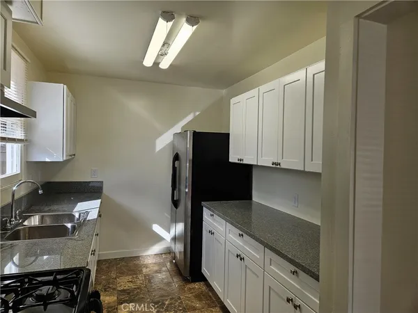 a kitchen with stainless steel appliances granite countertop a refrigerator stove and sink