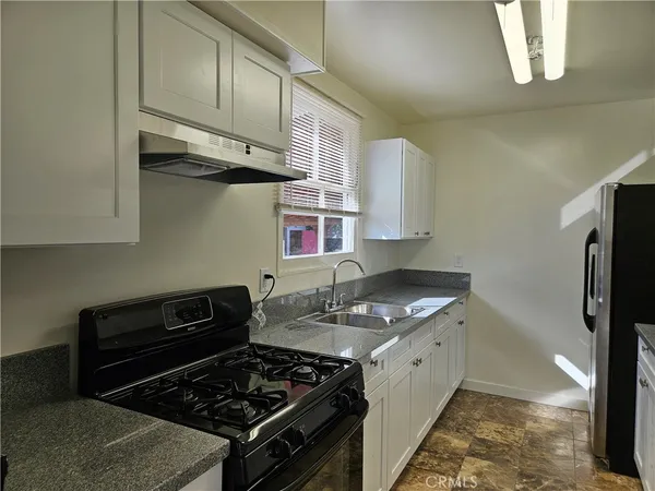 a kitchen with stainless steel appliances granite countertop a stove and a refrigerator