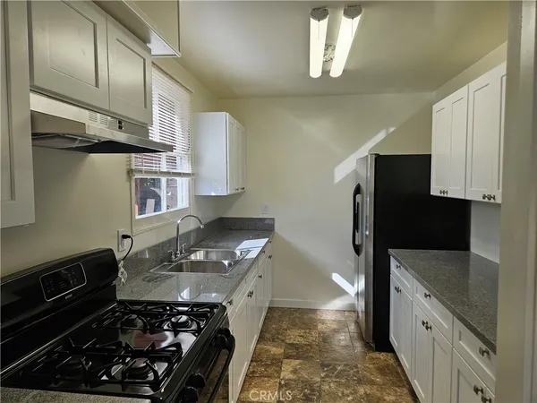 a kitchen with stainless steel appliances a stove a sink and a refrigerator