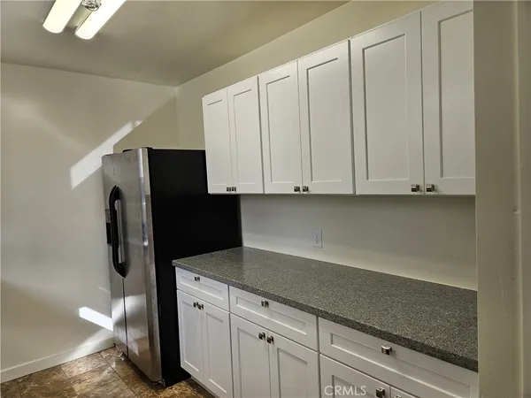 a kitchen with stainless steel appliances white cabinets and a refrigerator