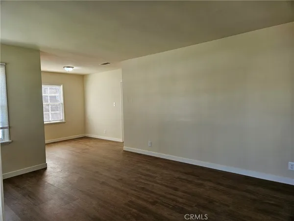 an empty room with a window and wooden floor