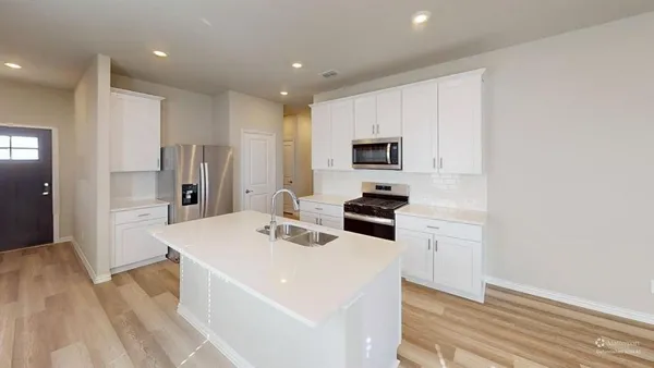 a kitchen with stainless steel appliances a refrigerator and a stove top oven
