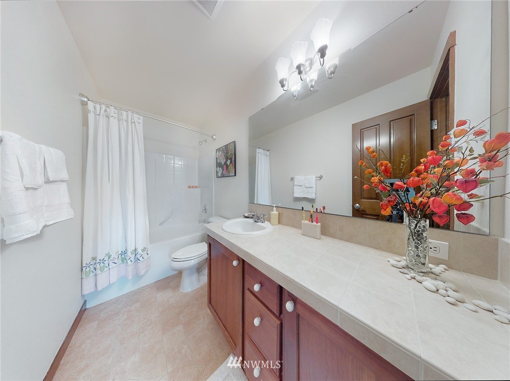 4002 216th Place Southeast Bothell, WA 98021 - Photo 25 of 28 a spacious bathroom with a granite countertop sink a large mirror and a shower