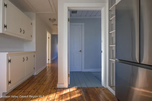 a view of a hallway with wooden floor