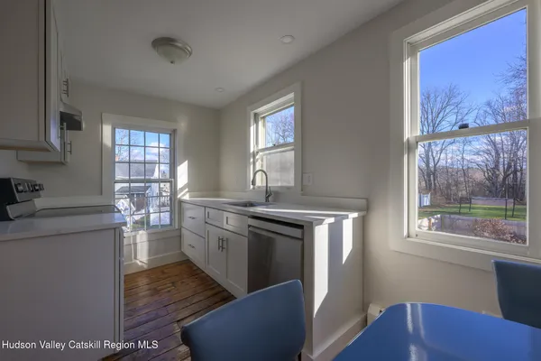 a kitchen with stainless steel appliances granite countertop a stove a sink dishwasher a refrigerator and wooden floor