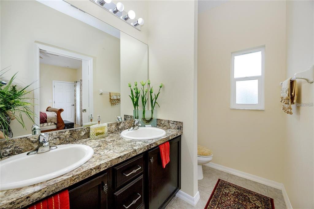 7820 Harbor Bridge Boulevard New Port Richey, FL 34654 - Photo 13 of 24 a bathroom with a granite countertop sink and a mirror