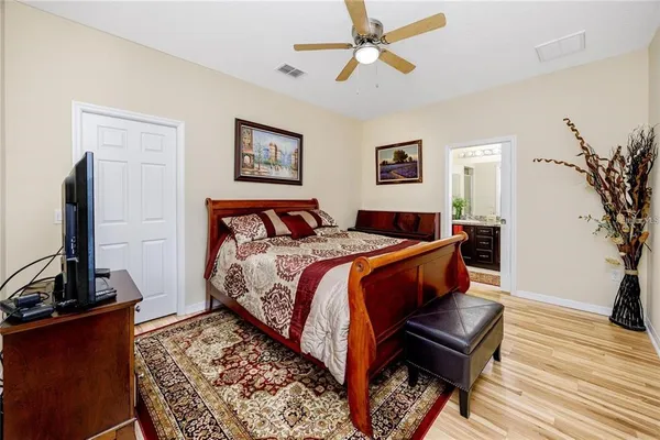 a bedroom with a bed and wooden floor