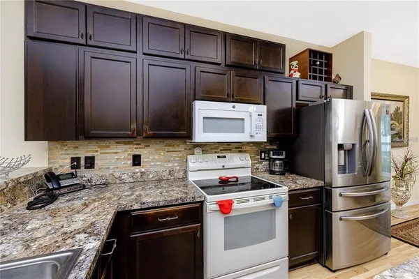 a kitchen with stainless steel appliances granite countertop a refrigerator stove and sink