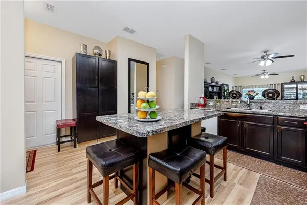 a kitchen with a refrigerator coffee maker table and chairs