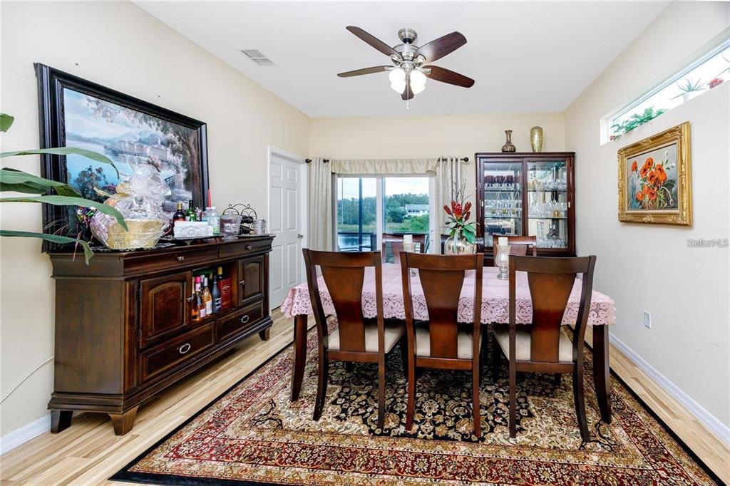 7820 Harbor Bridge Boulevard New Port Richey, FL 34654 - Photo 9 of 24 a dining room with furniture a rug and a fireplace