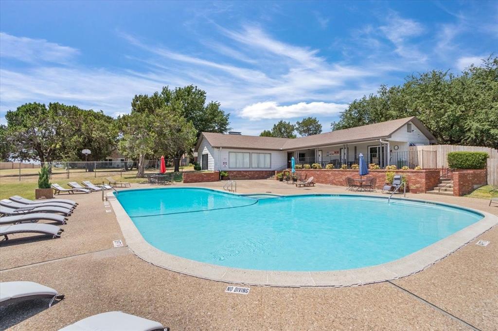 4108 Old Mill Road Waco, TX 76710 - Photo 36 of 39 Community pool -Resort-style swimming pool featuring crystal-clear waters, curved design with integrated shallow lounging area, and surrounding concrete decking with lounge seating