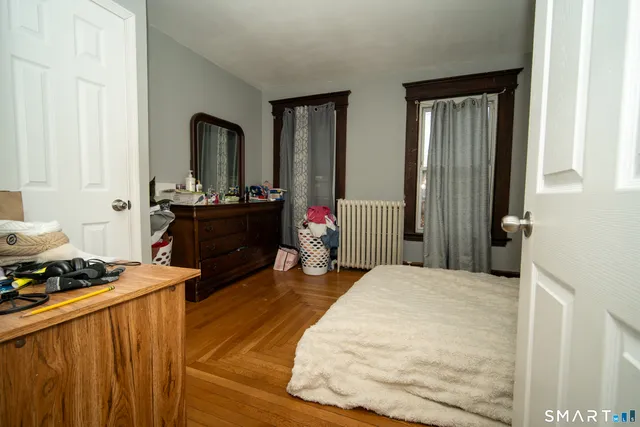 a bedroom with a bed and wooden floor