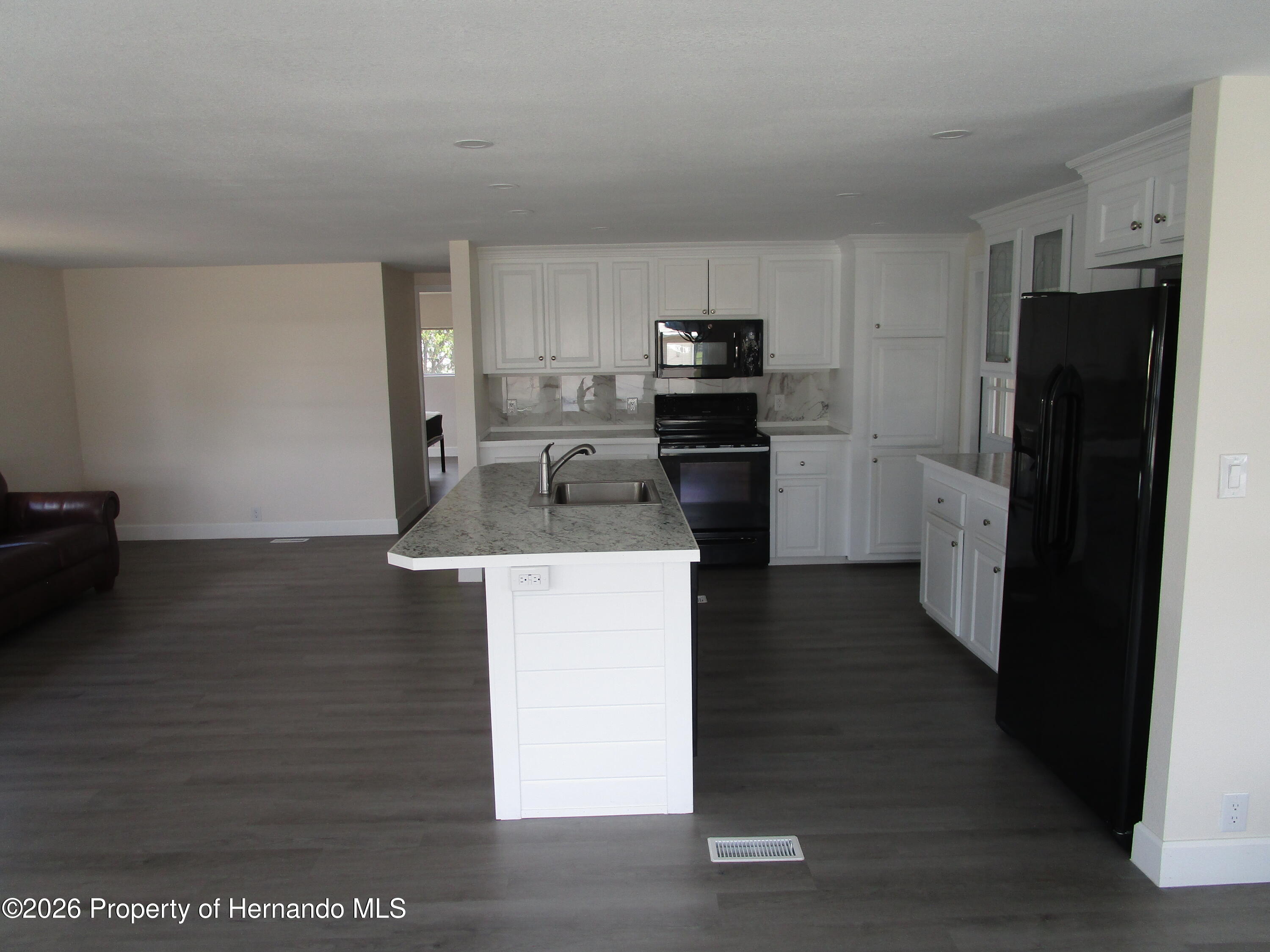 14790 Rialto Avenue, Unit 3 Brooksville, FL 34613 - Photo 3 of 15 a kitchen with a refrigerator stove and wooden floor