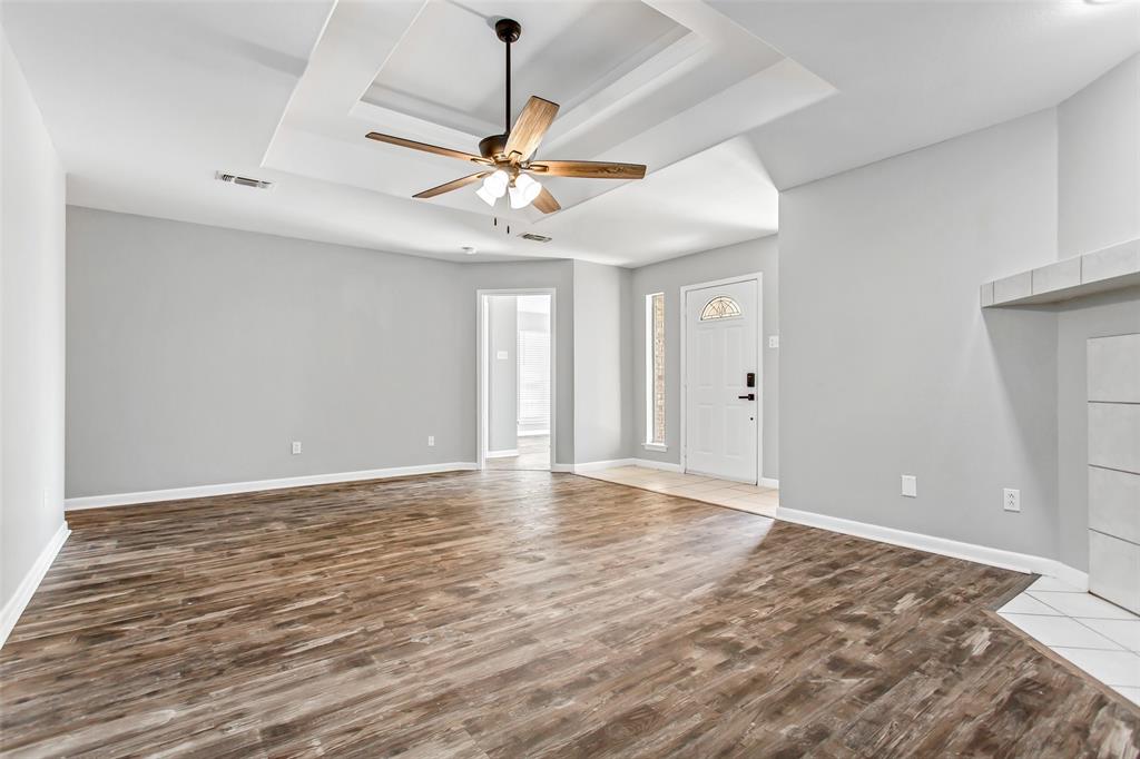 712 Billups Street Van Alstyne, TX 75495 - Photo 9 of 38 a view of an empty room with window and wooden floor