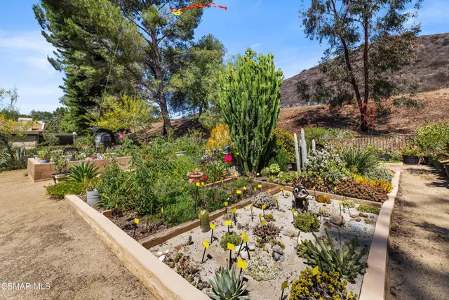 a view of a room with lots of wooden furniture and large windows
