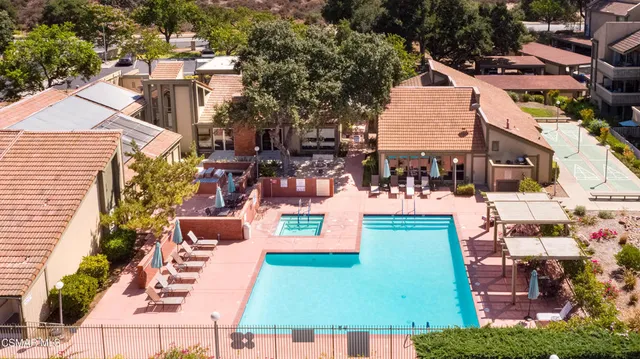 a view of a tables and chairs under an umbrella in backyard