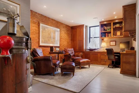 a living room with furniture a bookshelf and a window