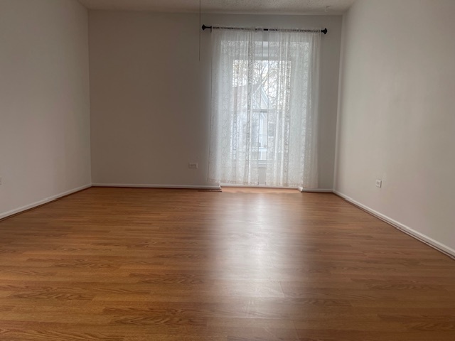 1302 Inverrary Lane, Unit 1302 Deerfield, IL 60015 - Photo 14 of 20 wooden floor in an empty room with a window