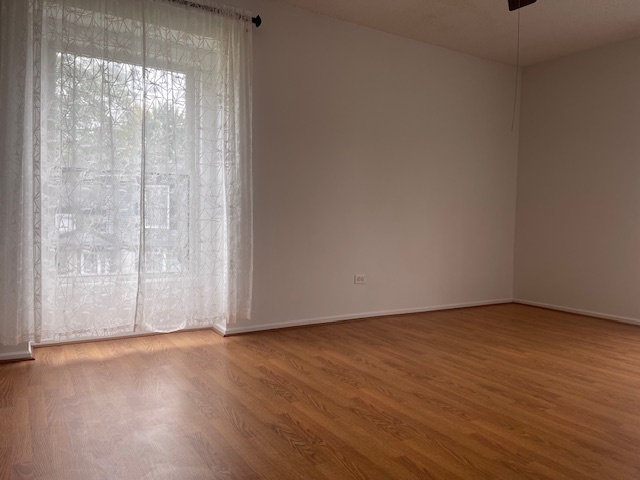 1302 Inverrary Lane, Unit 1302 Deerfield, IL 60015 - Photo 15 of 20 a view of an empty room with wooden floor and a window