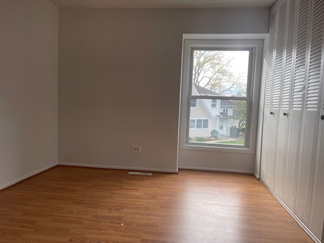 1302 Inverrary Lane, Unit 1302 Deerfield, IL 60015 - Photo 9 of 20 an empty room with wooden floor and windows