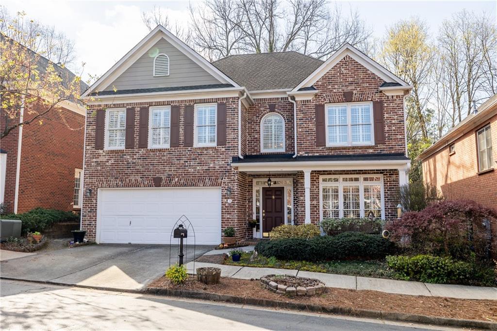 a front view of a house with yard and parking