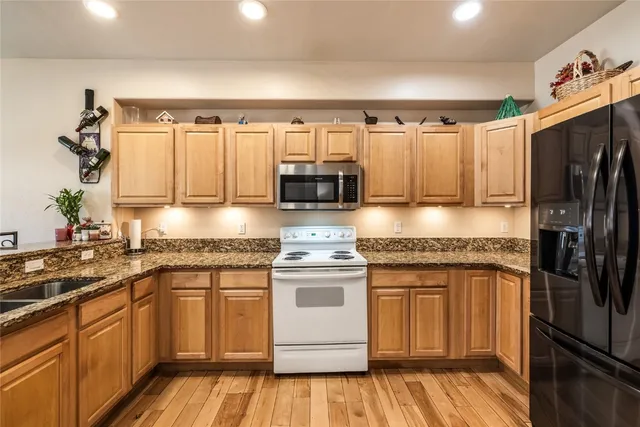 a kitchen with stainless steel appliances granite countertop a refrigerator and a stove top oven