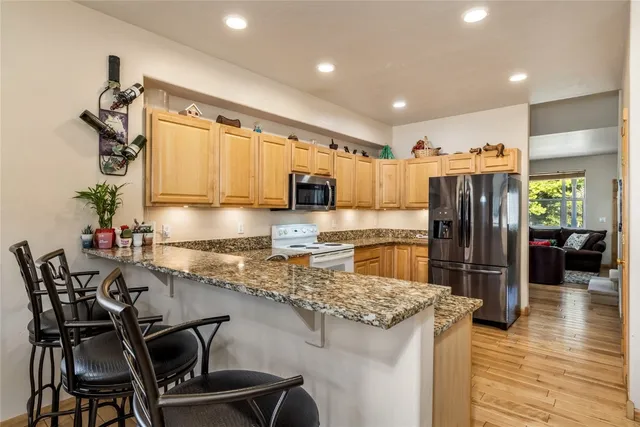 a kitchen with kitchen island granite countertop wooden cabinets and stainless steel appliances