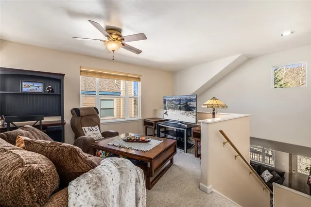 a living room with furniture ceiling fan and a window