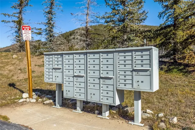 a front view of a building with large trees