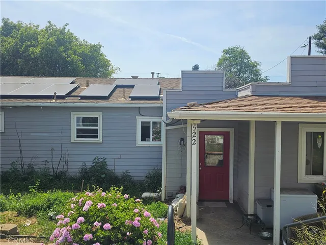 a front view of a house with a yard and tree s