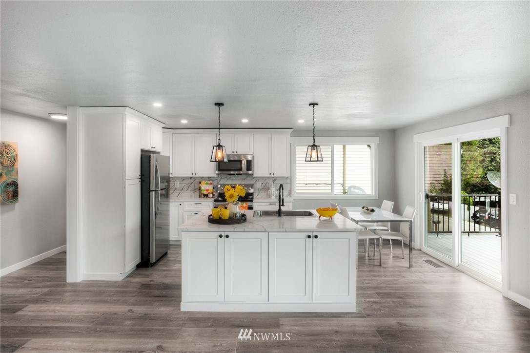 405 Maple Avenue Northwest Renton, WA 98057 - Photo 4 of 23 a kitchen view with stainless steel appliances a dining table chairs and wooden floor