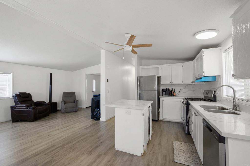 400 Greenfield Drive El Cajon, CA 92021 - Photo 15 of 41 a kitchen that has a lot of cabinets a sink and wooden floor